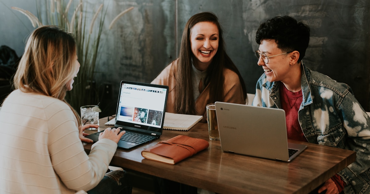 Groupe de personnes souriantes pratiquant la conversation en anglais autour d'une table