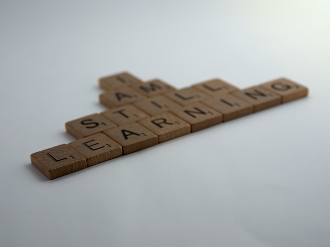 Lettres de Scrabble formant la phrase I am still learning, symbolisant l'apprentissage continu de l'anglais