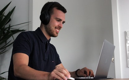 Adulte professionnel apprenant l'anglais en ligne avec un casque et un ordinateur portable