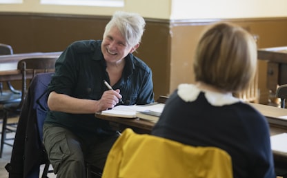 Femme de 50 ans qui apprend l'anglais en prenant des notes dans un cahier