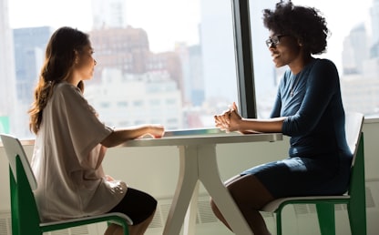 Deux femmes en conversation illustrant les difficultés à parler anglais dans un échange oral