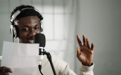 Homme pratiquant sa prononciation anglaise devant un microphone avec un casque audio
