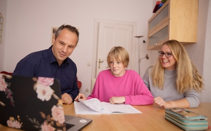 Parents aidant leur fille à apprendre l'anglais ensemble à la maison