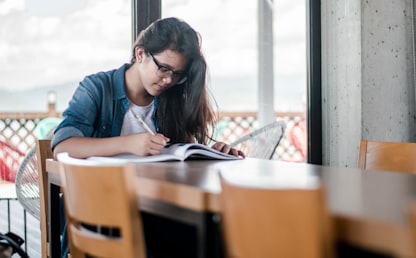 Femme écrivant dans un cahier pour reprendre l'anglais après des années