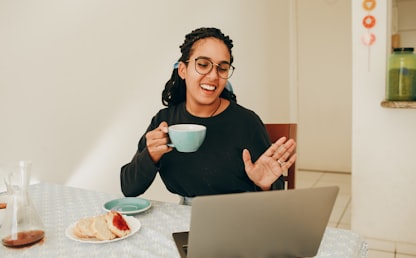 Apprenante souriante suivant un cours de langue en ligne en visioconférence