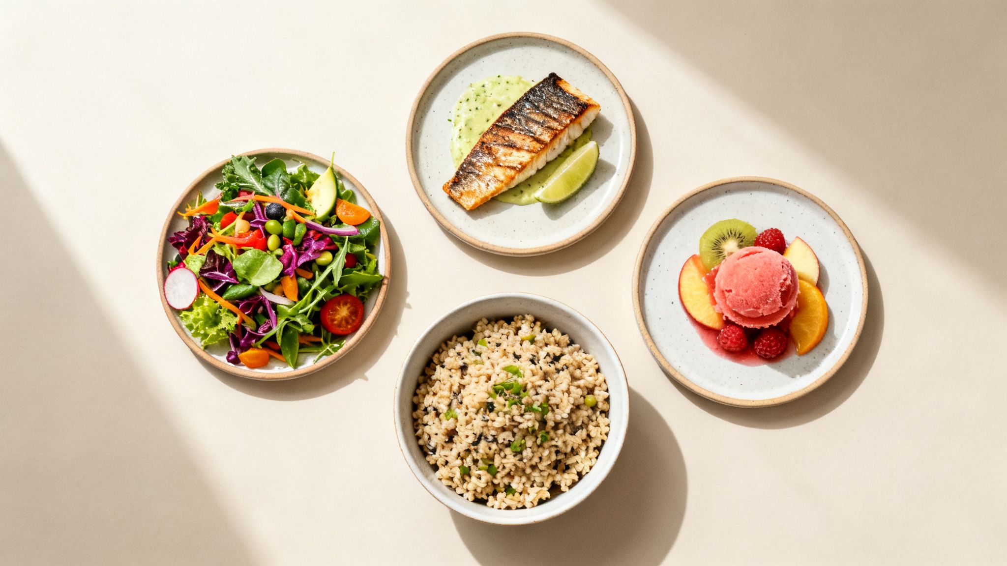 Comida saludable y equilibrada con ensalada fresca, pescado a la parrilla, arroz y postre de frutas con sorbete, vista aérea.