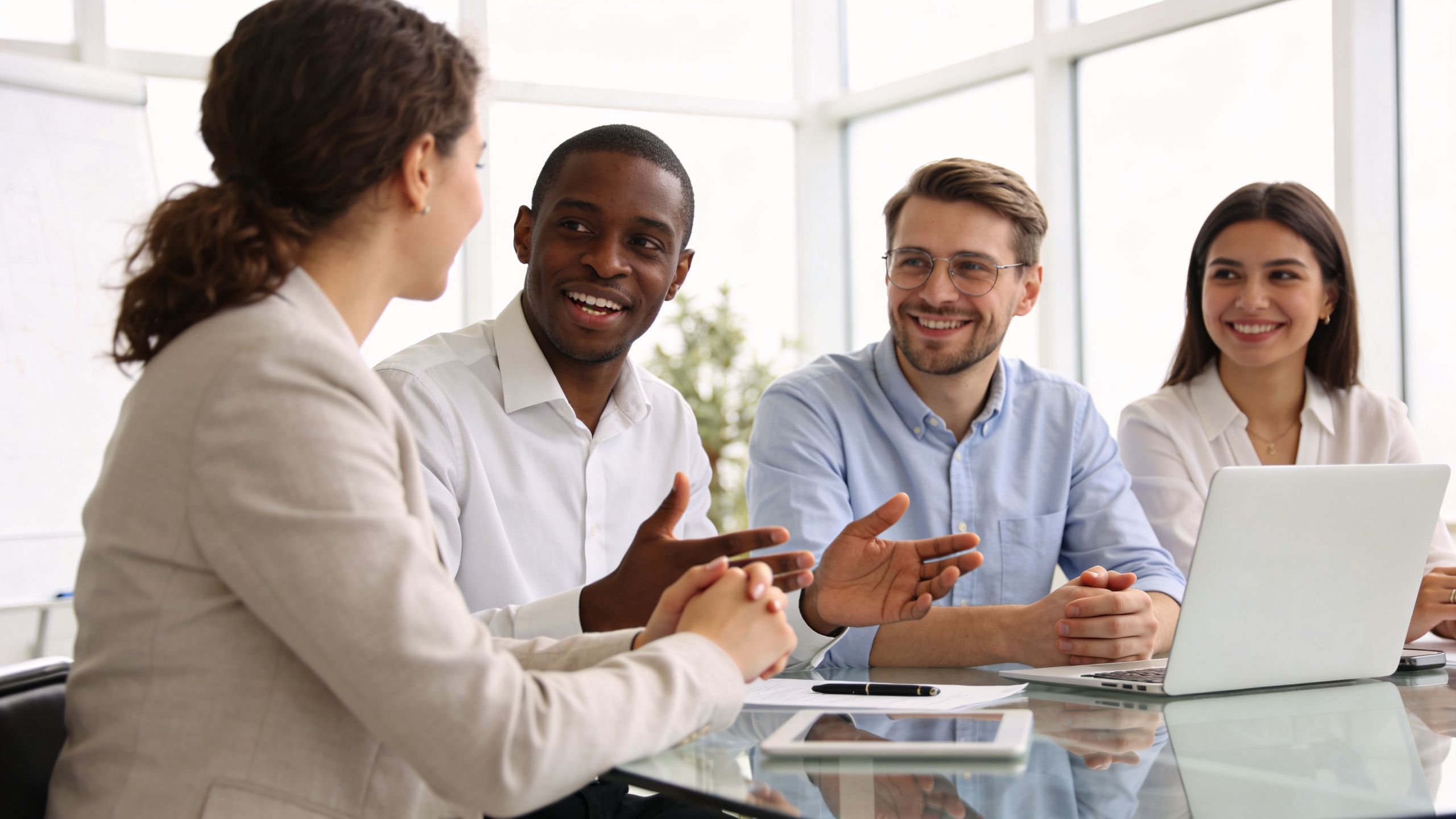 Un grupo de profesionales diversos colaborando y discutiendo ideas en una reunión de negocios en la oficina.