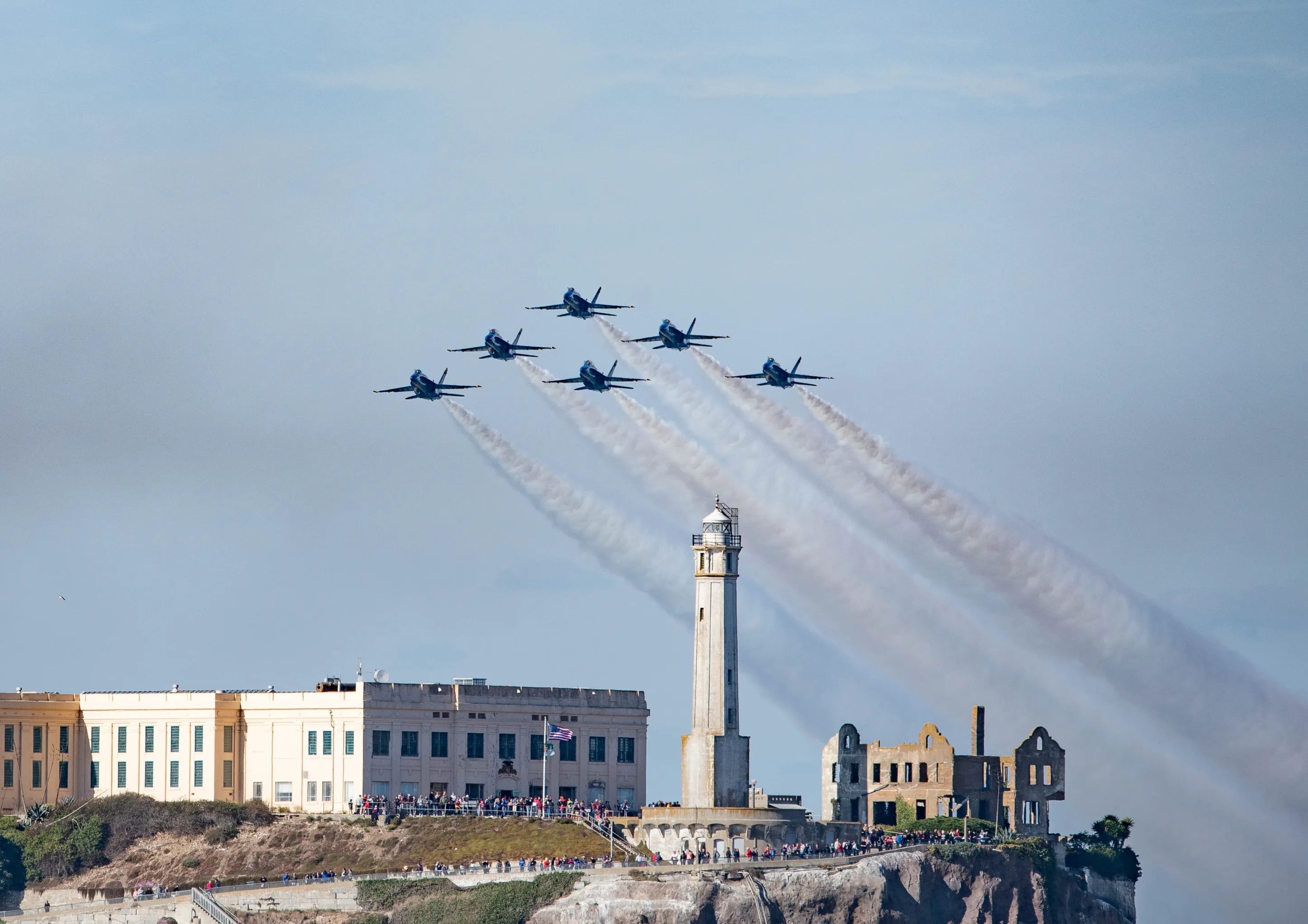 Navy jets in tight formation trailing smoke as they streak over San Francisco Bay during the Fleet Week air show.