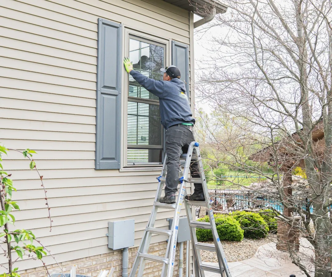 window being installed by man on ladder