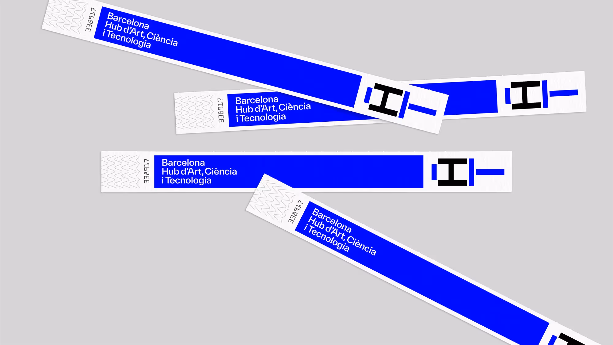 An overhead view of admittance wristbands laid on a flat grey background.