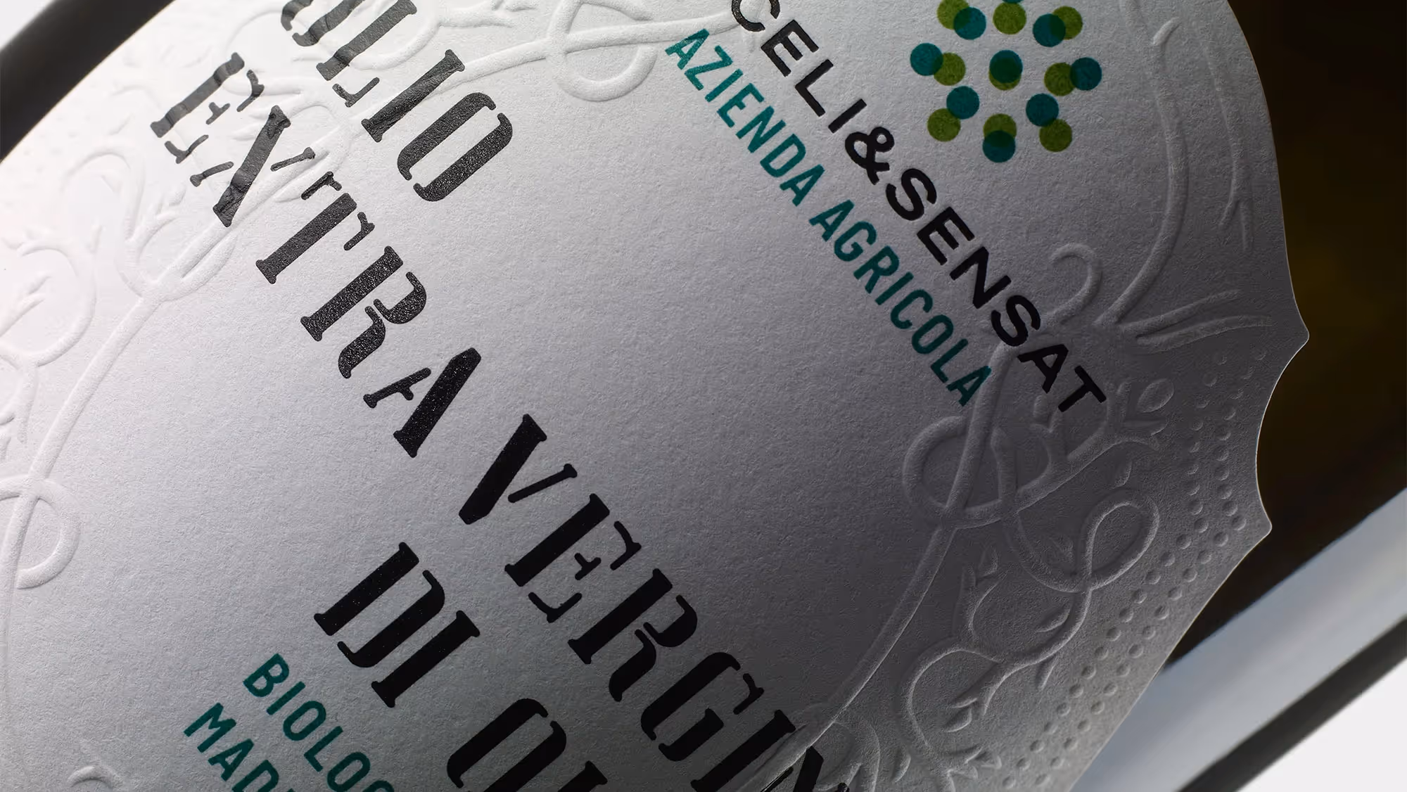 Angled detail of the olive oil label, highlighting the traditional Italian embossing.