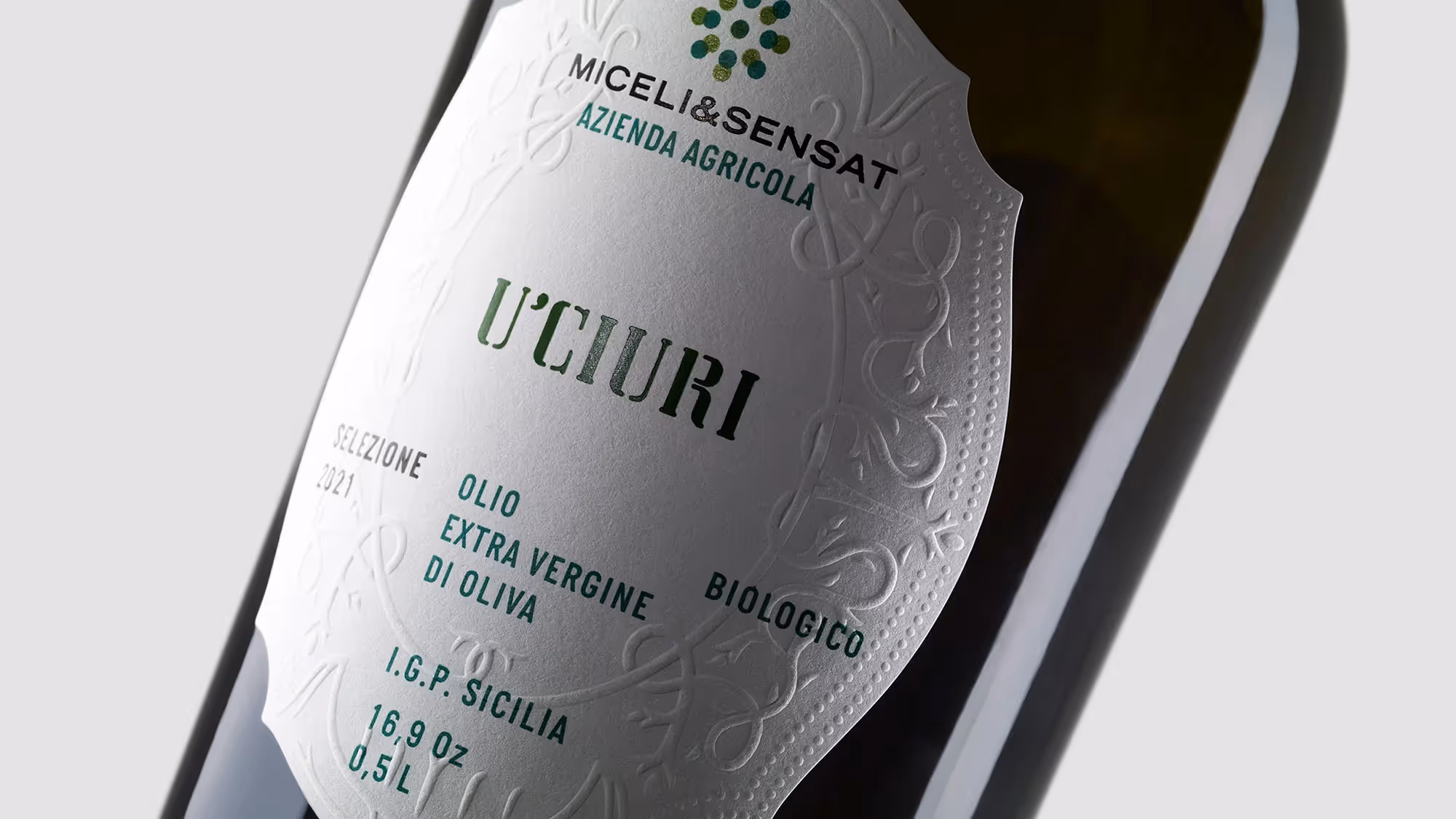 Angled view of the U'Ciuri olive oil label, highlighting the traditional Italian embossing.