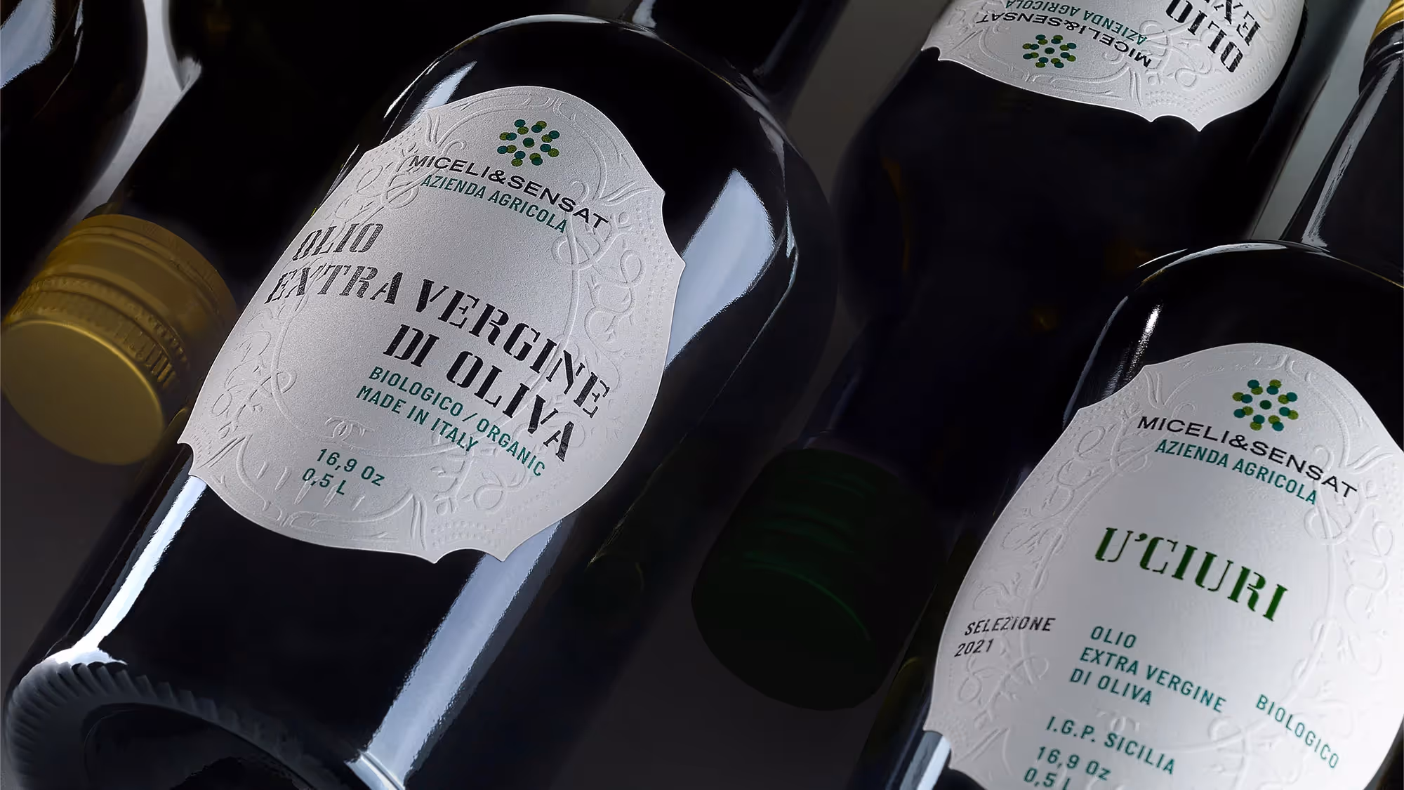 An offset grid of olive oil bottles laying on their side, displaying the label.