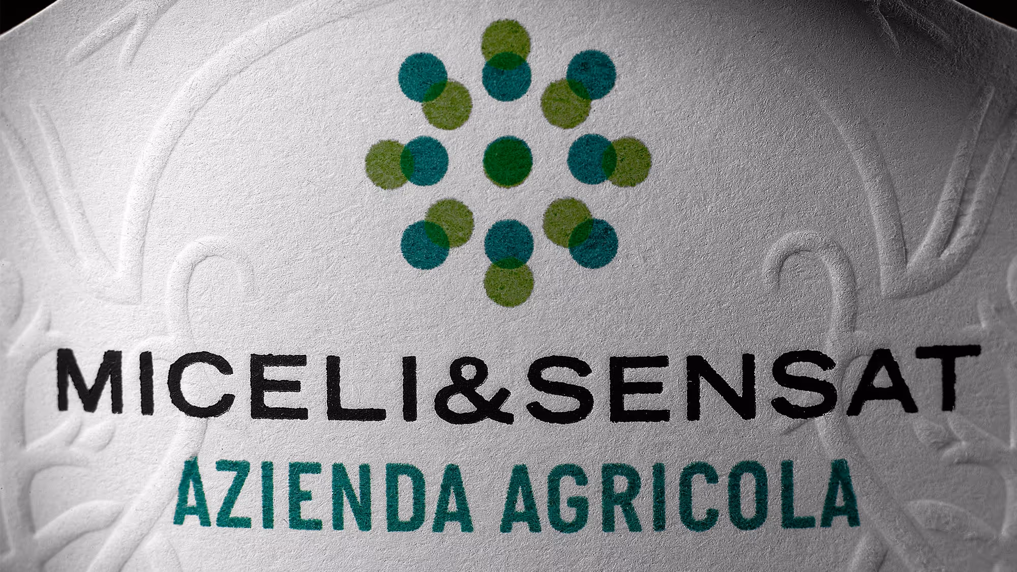 Detail of the Miceli & Sensat logo printed on the olive oil bottle.