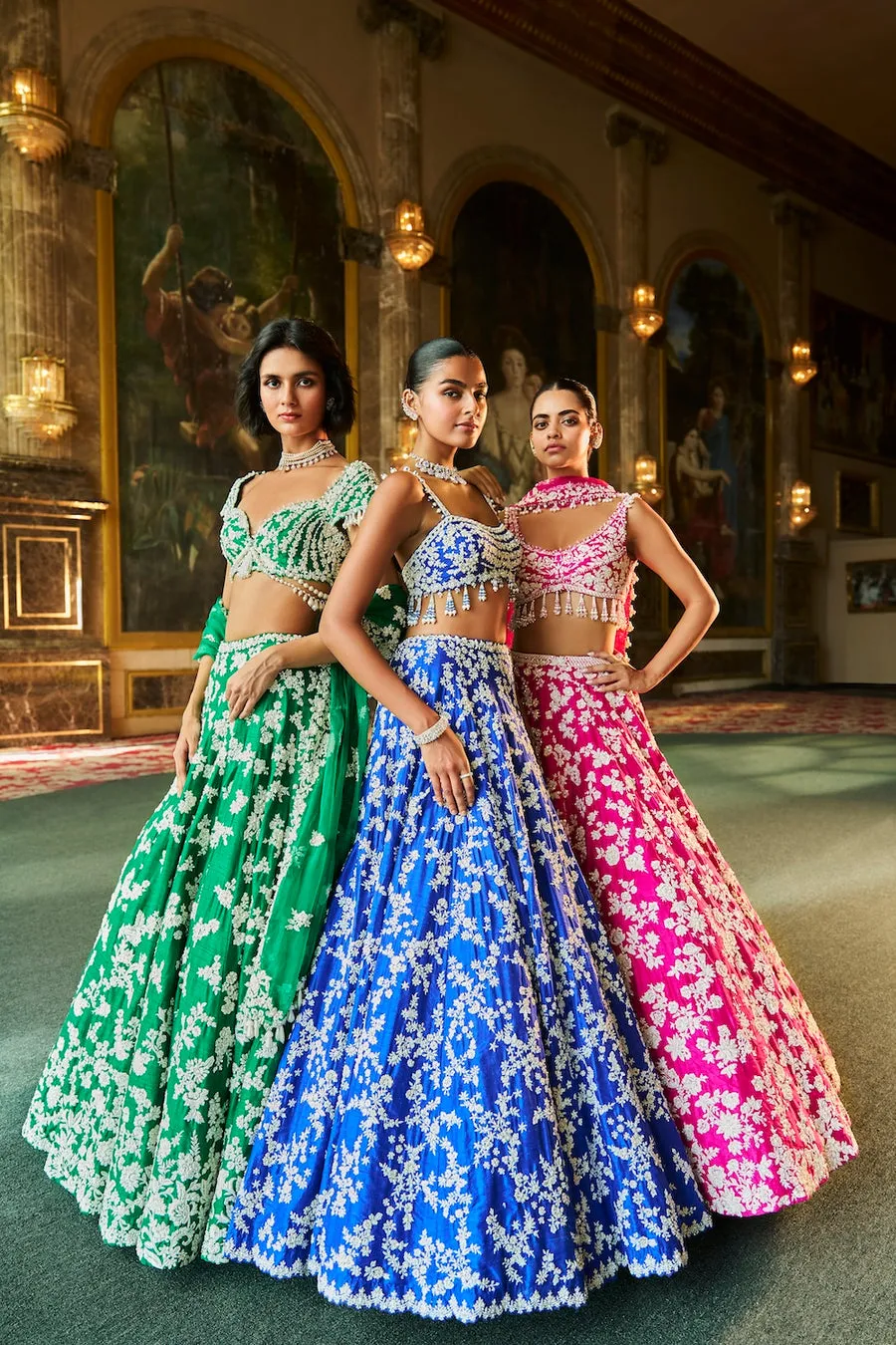 This emerald green lehenga is a luminous ode to nature-inspired couture, adorned with intricate ivory floral embroidery that cascades gracefully across the silhouette. The exquisitely crafted blouse features ornate handwork and delicate edging, creating a harmonious balance of structure and softness. A matching dupatta, lightly embellished, frames the ensemble with refined elegance and fluid movement. Fresh yet opulent, this creation embodies timeless artistry with a celebratory, regal presence.
