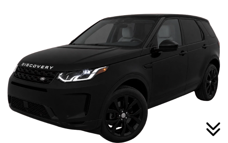 Black Land Rover Discovery SUV viewed from the front left side with headlights on.
