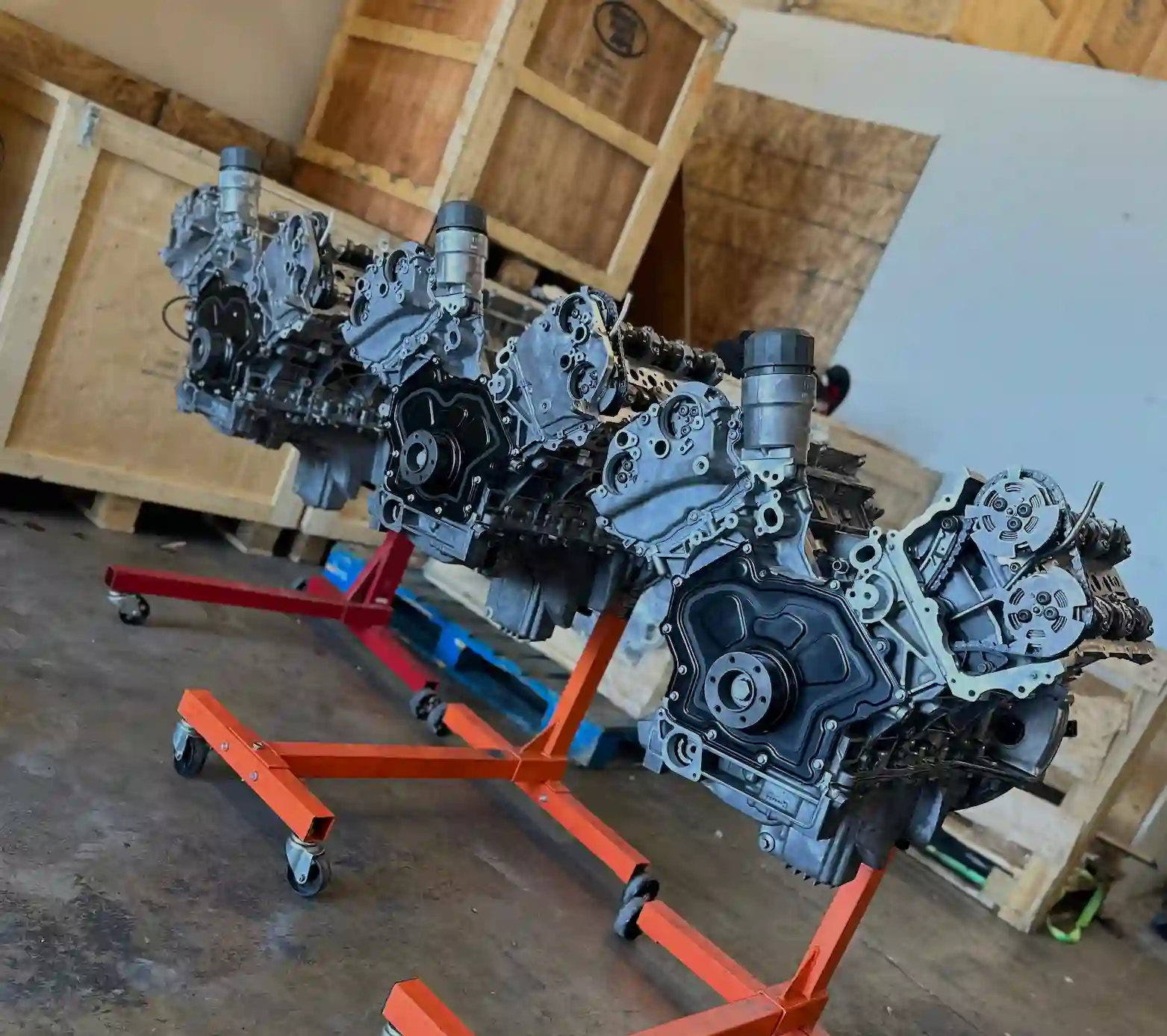 Four precision-built Land Rover engines mounted on orange engine stands in Rover Parts Depo's Shop. 