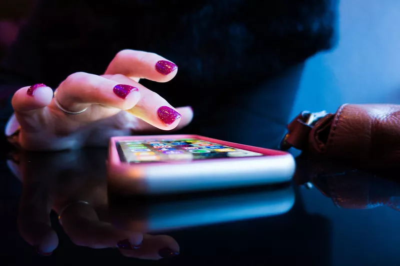woman using her iphone on a table