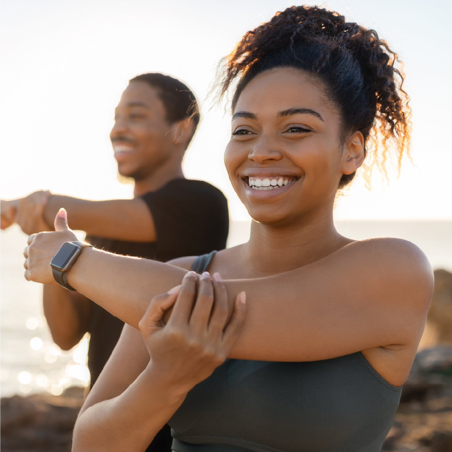Healthy woman smiling and stretching outdoors after finding sinus relief