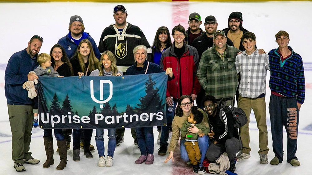 Employees from Uprise Partners gathered on an ice rink during an employee get together