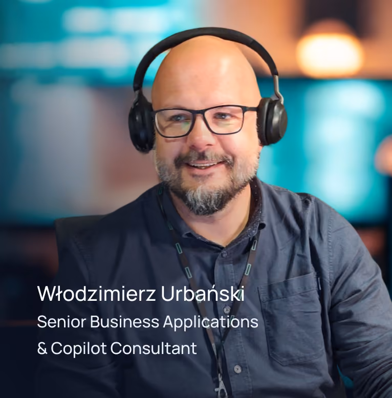 Uśmiechnięty mężczyzna z łysą głową, okularami i słuchawkami na uszach z rozmytym tłem.