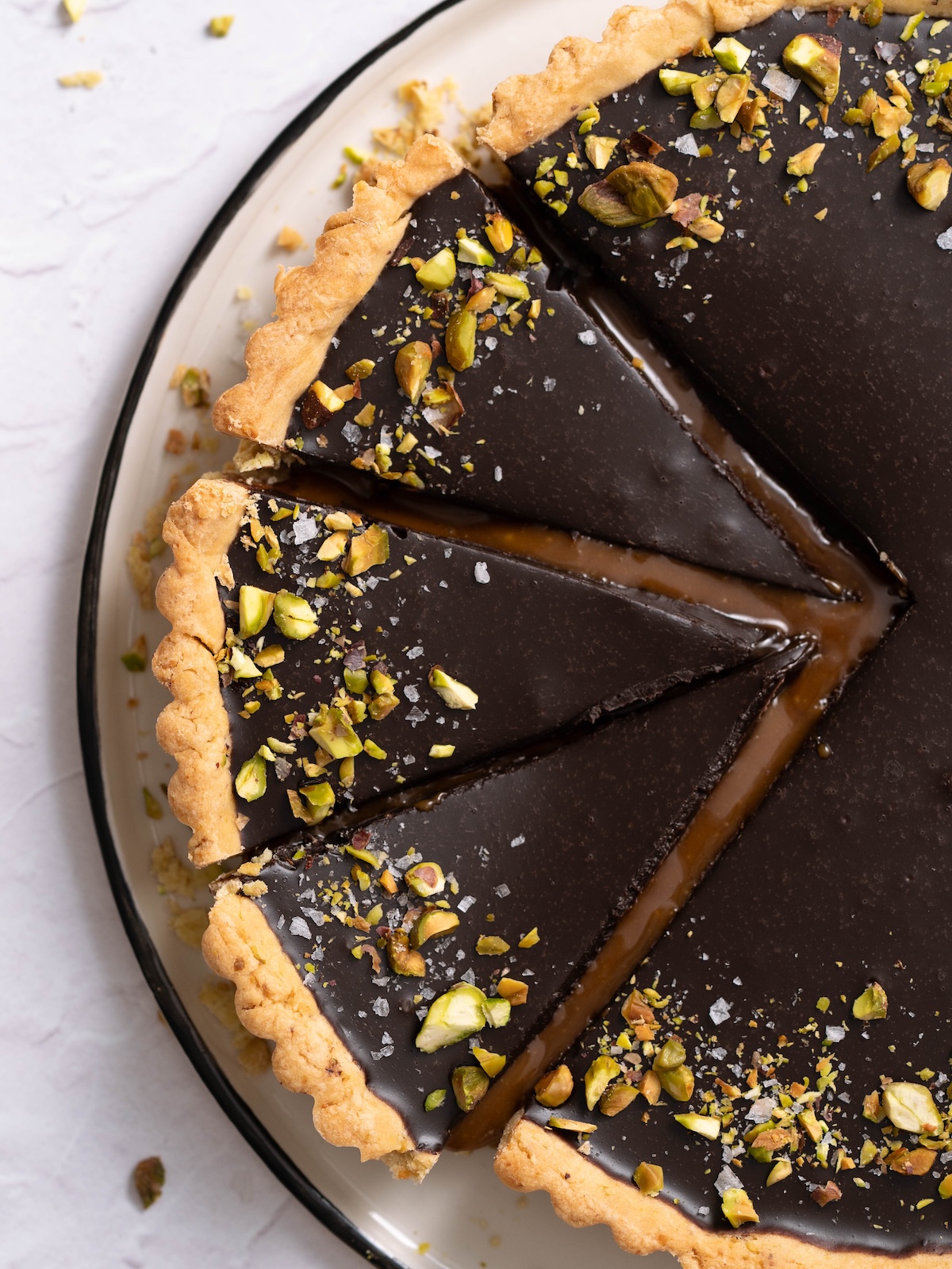 Gooey slices of chocolate caramel tart topped with pistachios