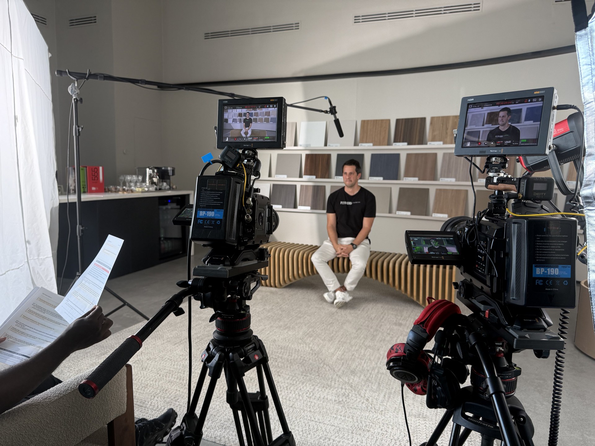 Plywood Express BTS — wide two-camera setup, subject between cameras on wooden bench