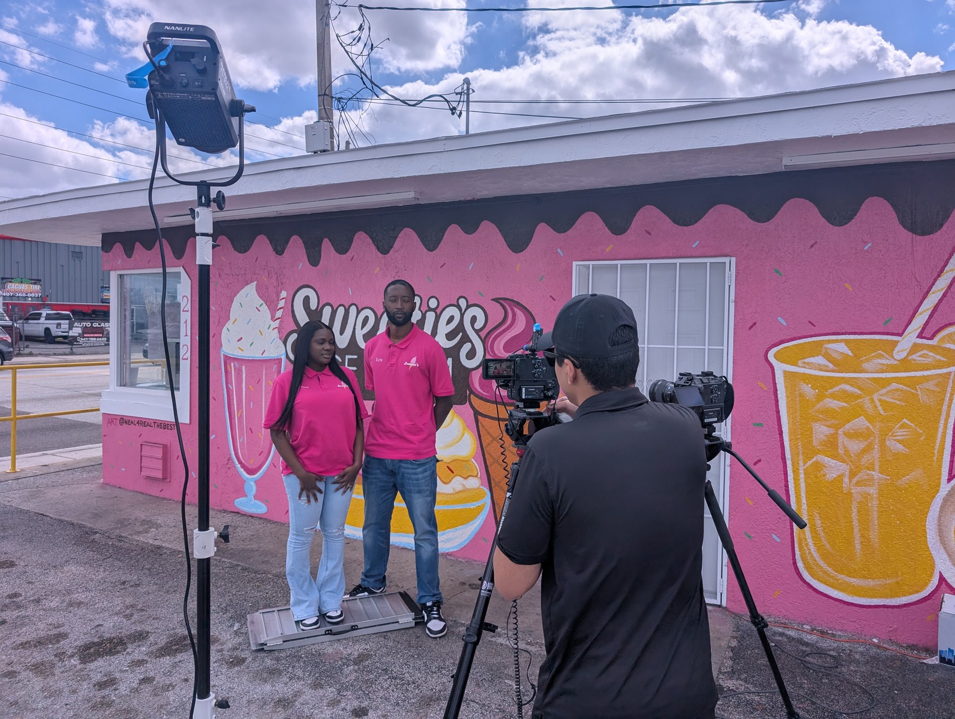 OBT NEXT — Sweeties Ice Cream, owners in pink shirts in front of colorful OBT storefront mural