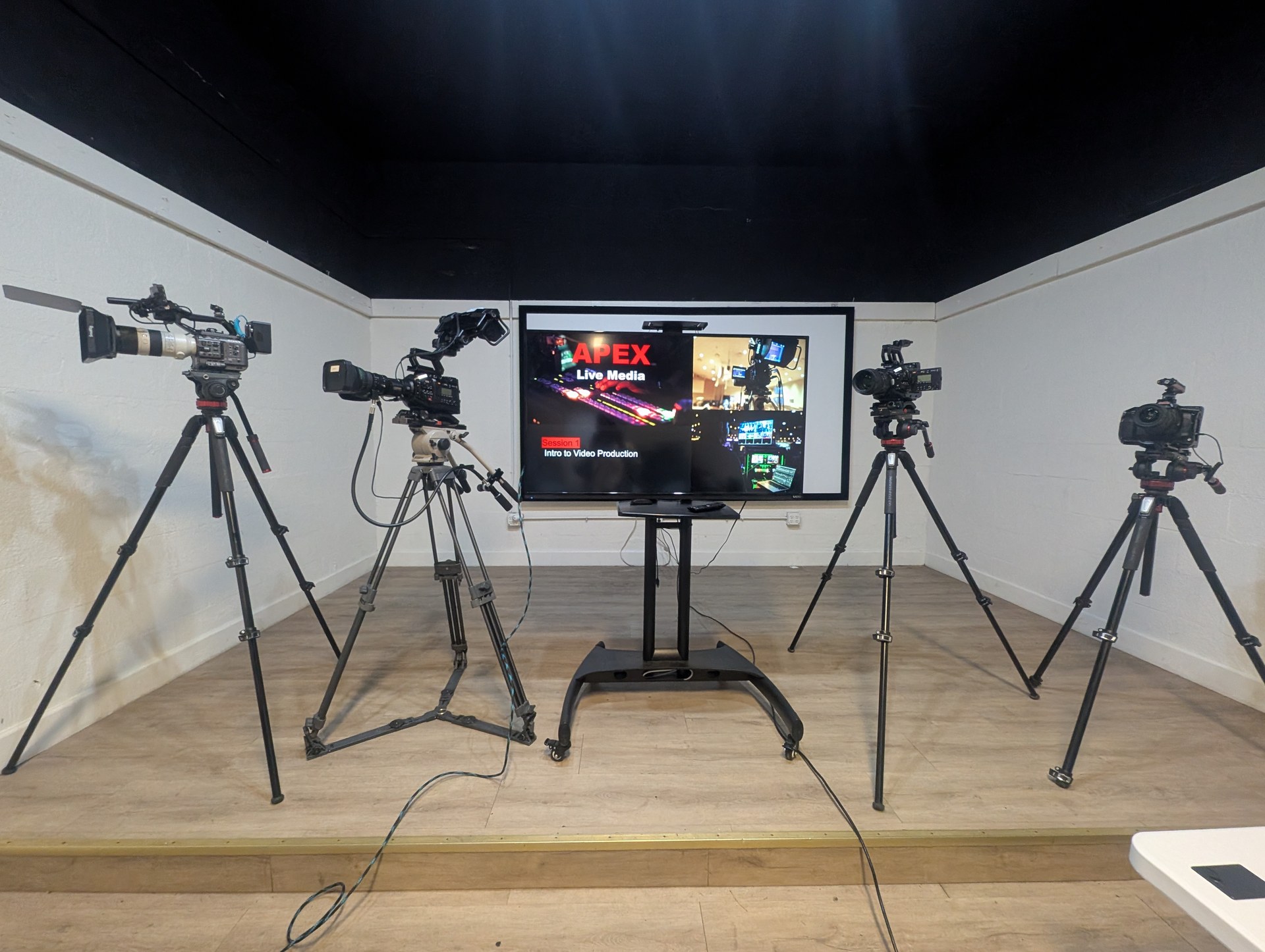 OBT NEXT — APEX Live Media AV Training Program, four cameras on tripods flanking intro video production screen