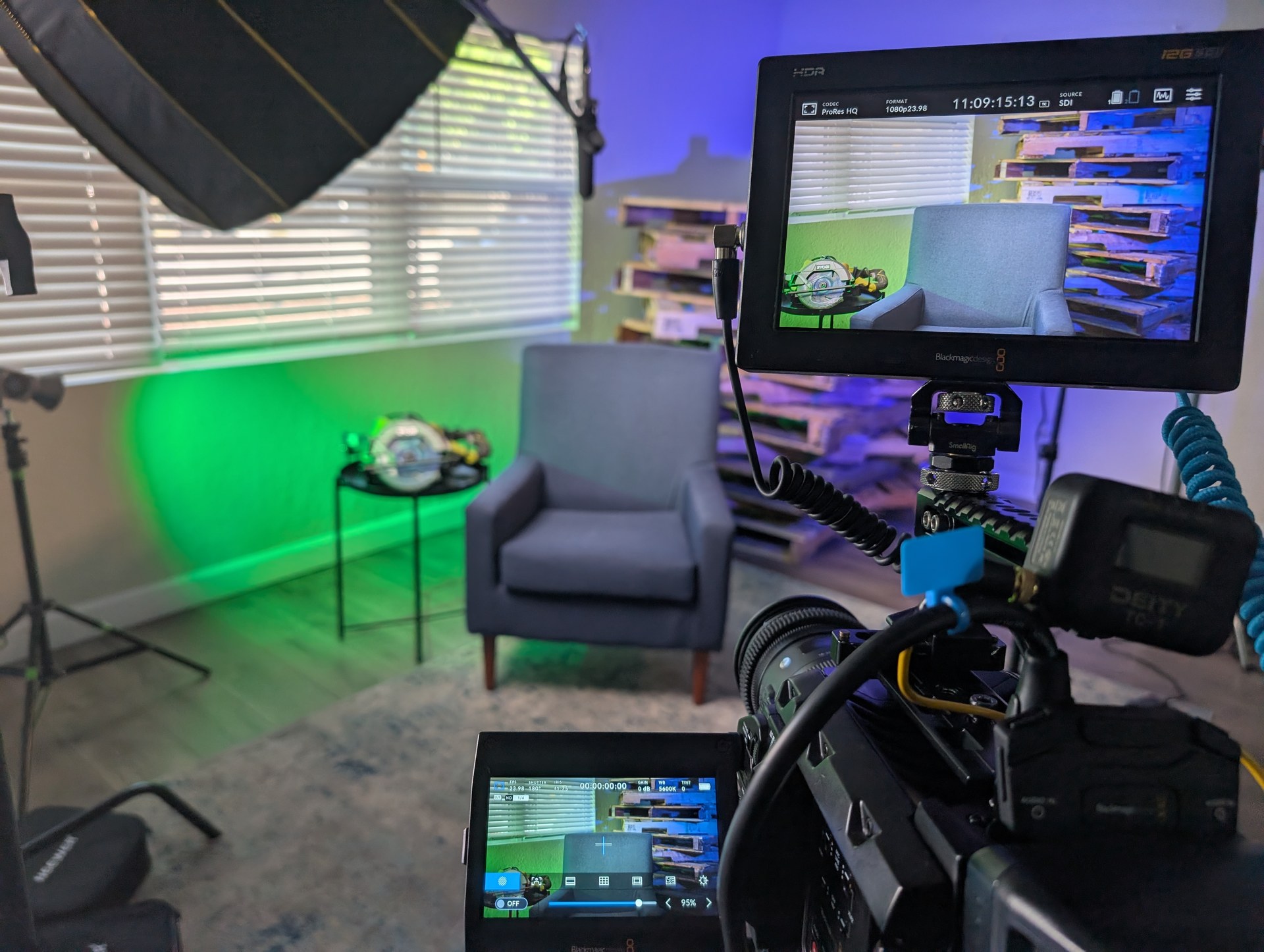 OBT NEXT — Burney Services BTS, Blackmagic camera monitor foreground, green neon accent light, pallet wood wall