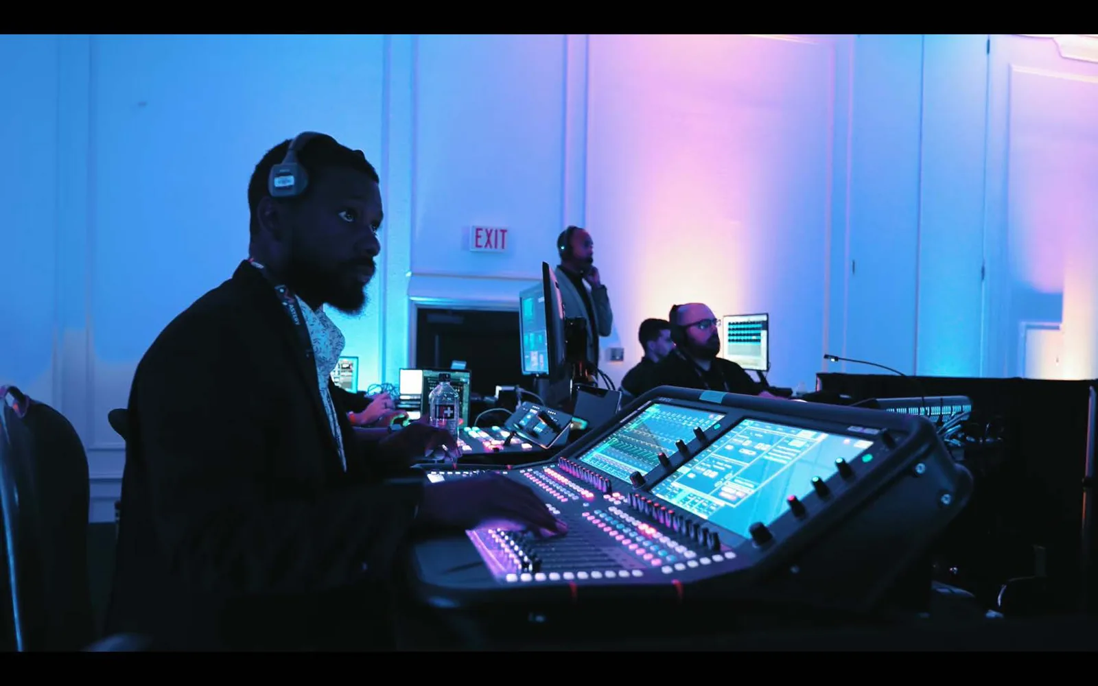 Audio engineer running the show from a lit front-of-house console