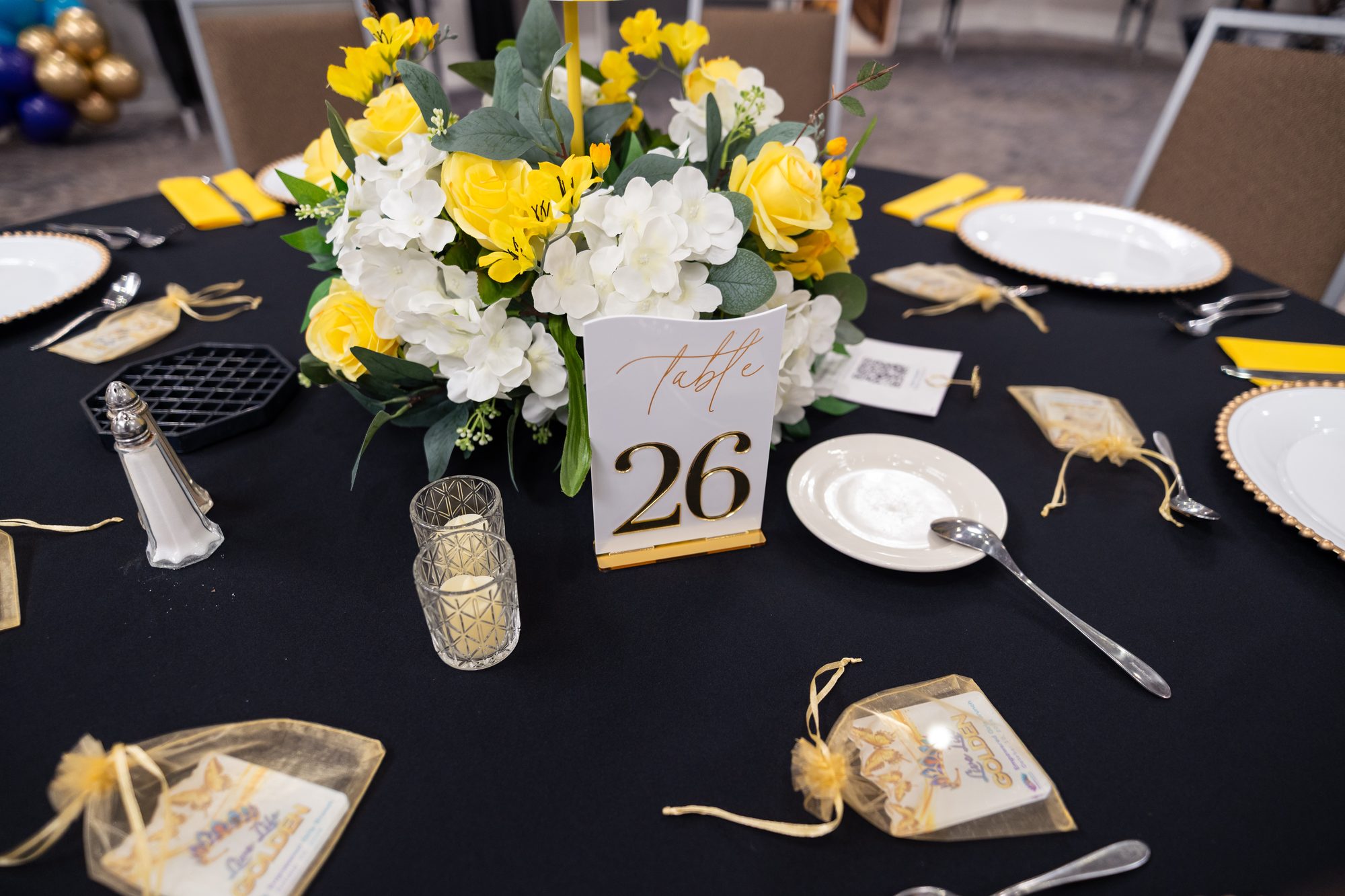 A gold and white centerpiece at a guest table