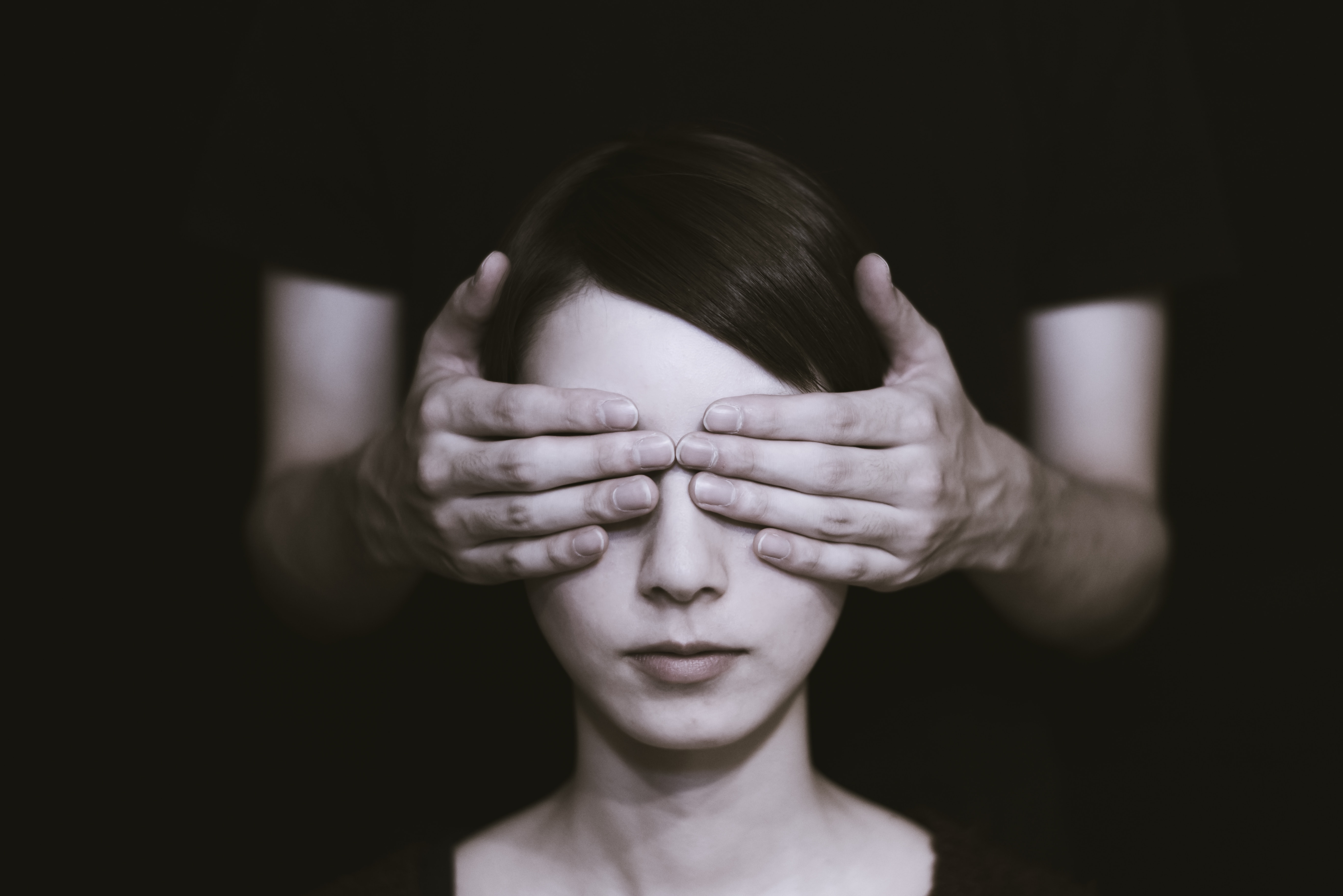 A person putting their hands over someones eyes