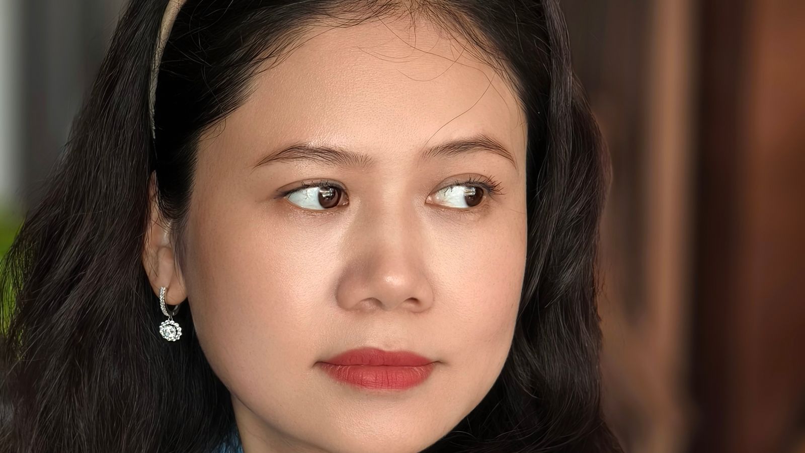 Portrait of thoughtful Asian woman in blue shirt, indoor