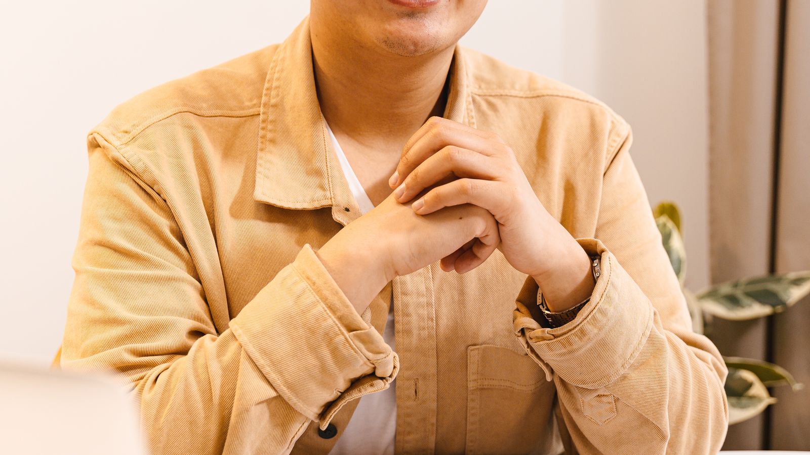 Confident Asian young man smiling at desk, notebook