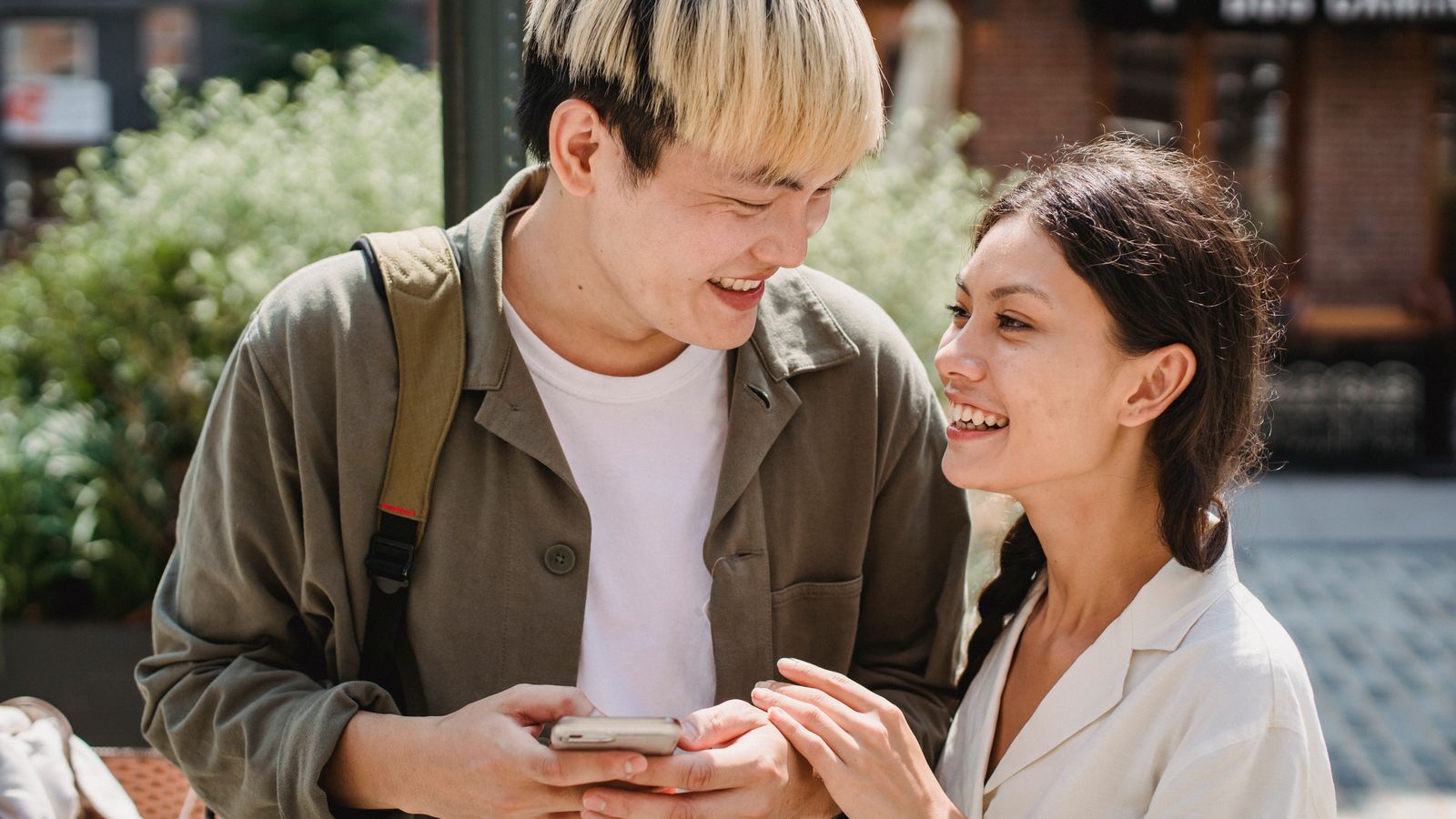 Multiethnic couple smiling looking at each other on street