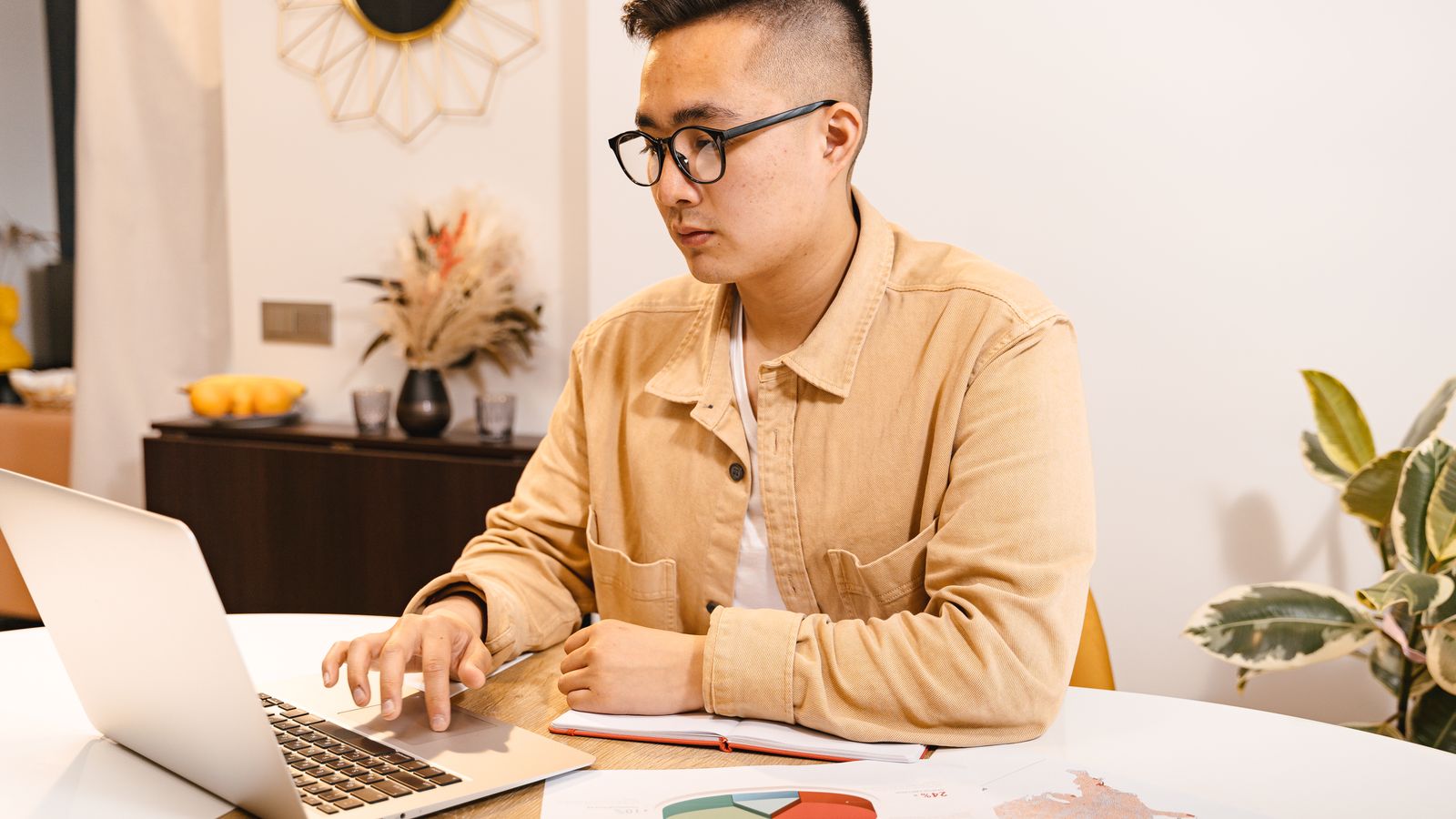 Young Asian man focused on work, laptop home office
