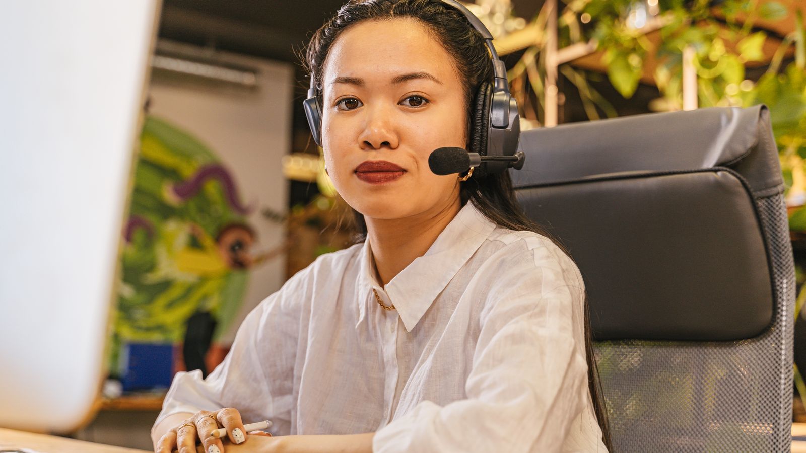 Asian woman in office wearing headset, call center
