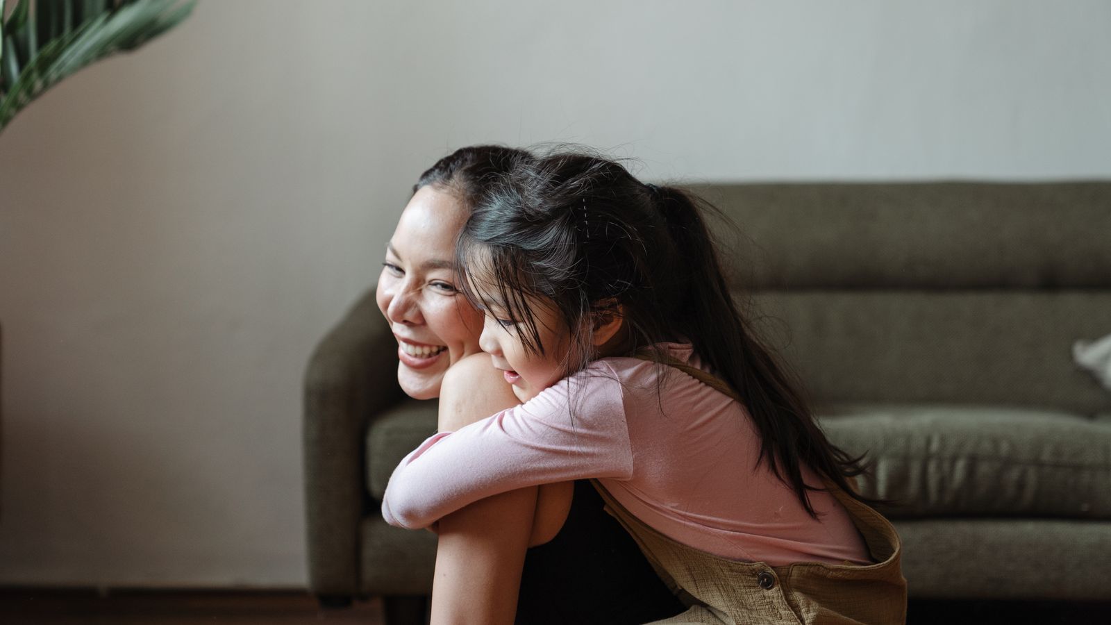 Mother and daughter warm embrace, cozy home