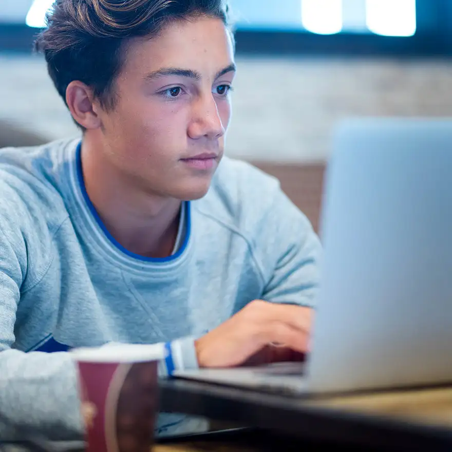 Schüler vor Laptop recherchiert im Internet