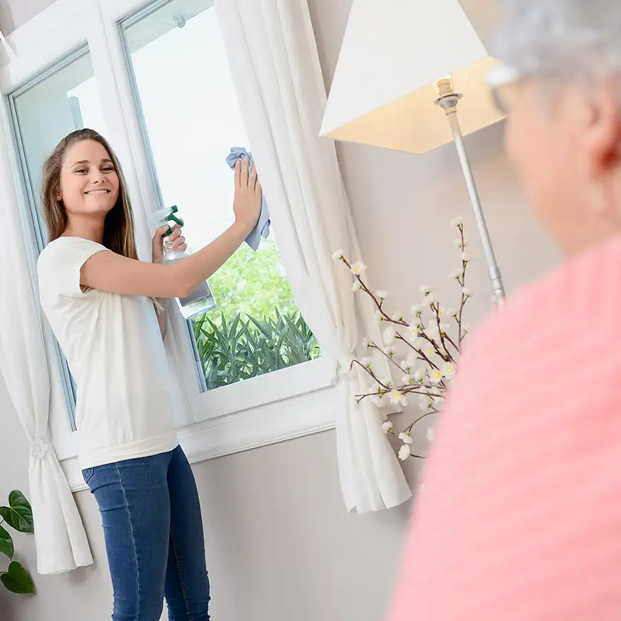 Schülerin putzt Fenster als Haushaltshilfe bei Rentnerin