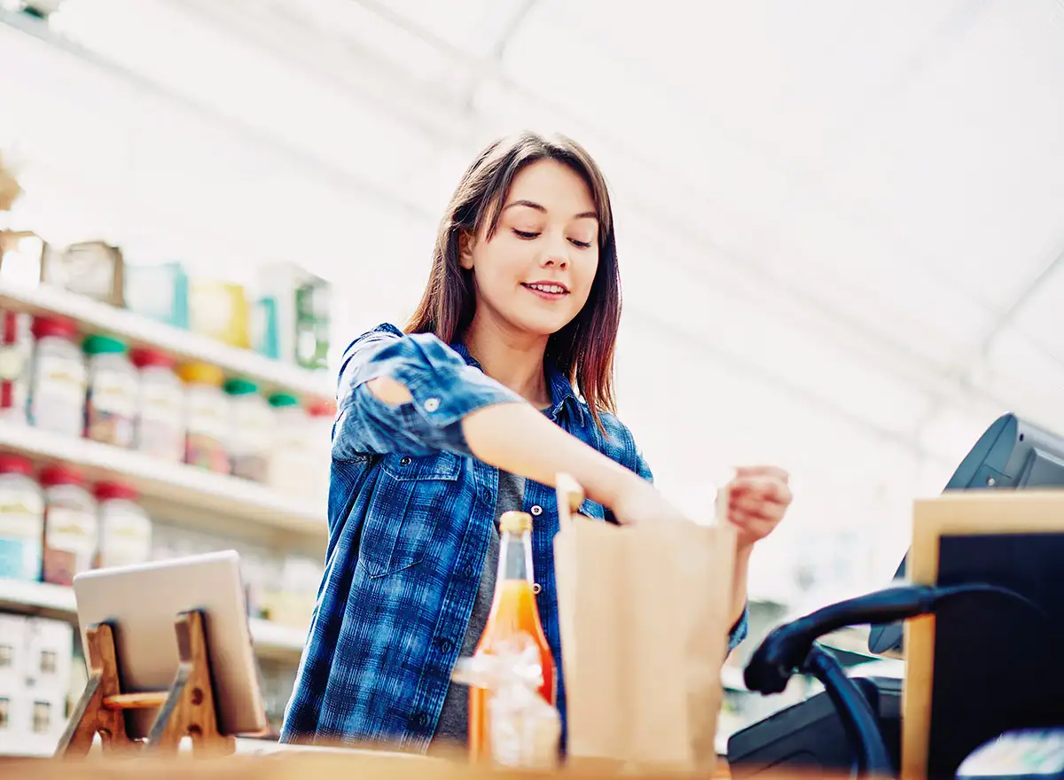 Schülerin als Einpackhilfe an der Kasse