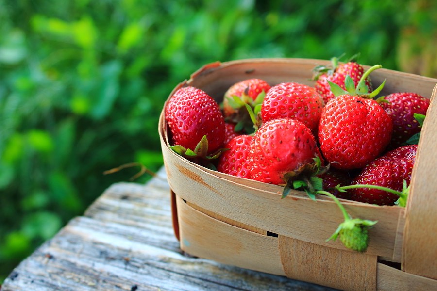 Strawberries in a basket on a wooden table