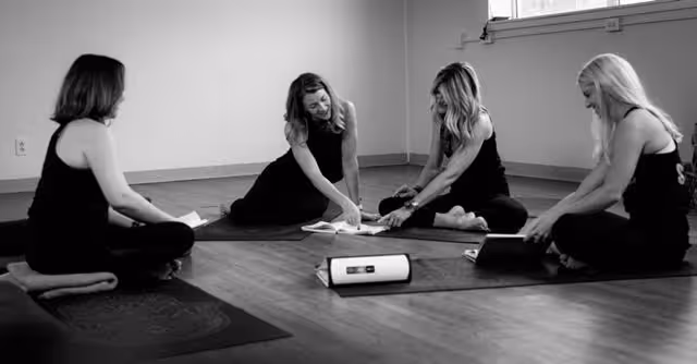 Yoga students practicing downward dog under the guidance of instructor Stacey Reynolds