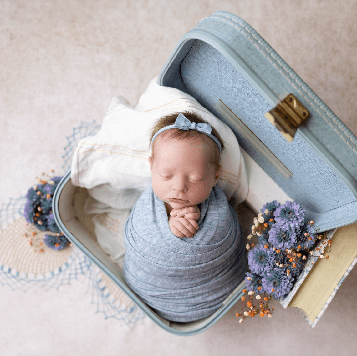 baby sleeps in a blue suitcase newborn photography billings mt