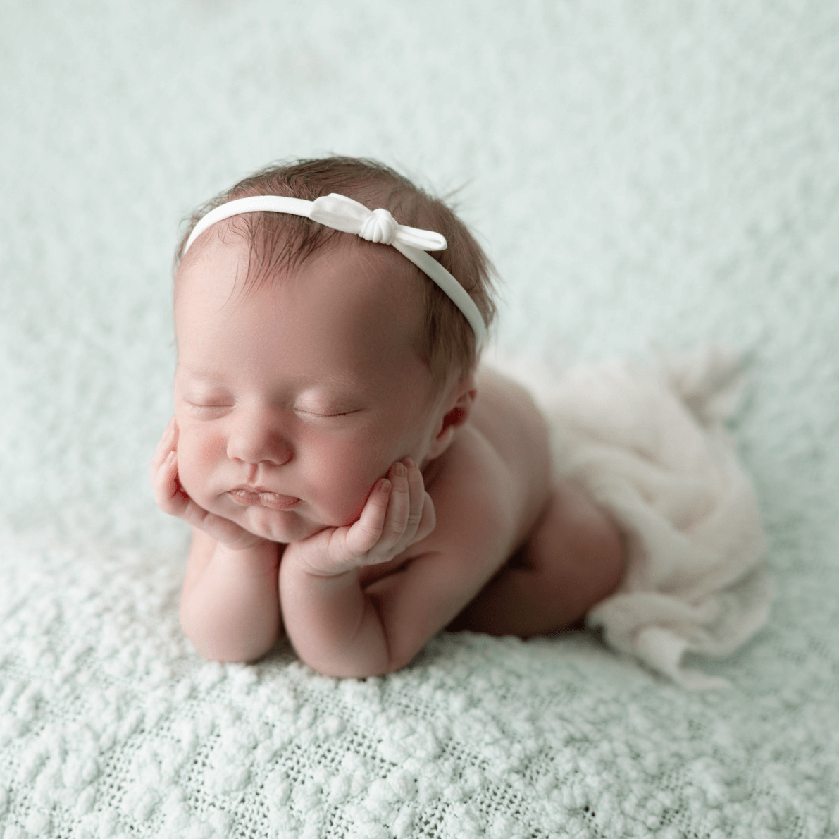 a baby girl sleeps in a froggy pose for newborn photography session billings mt