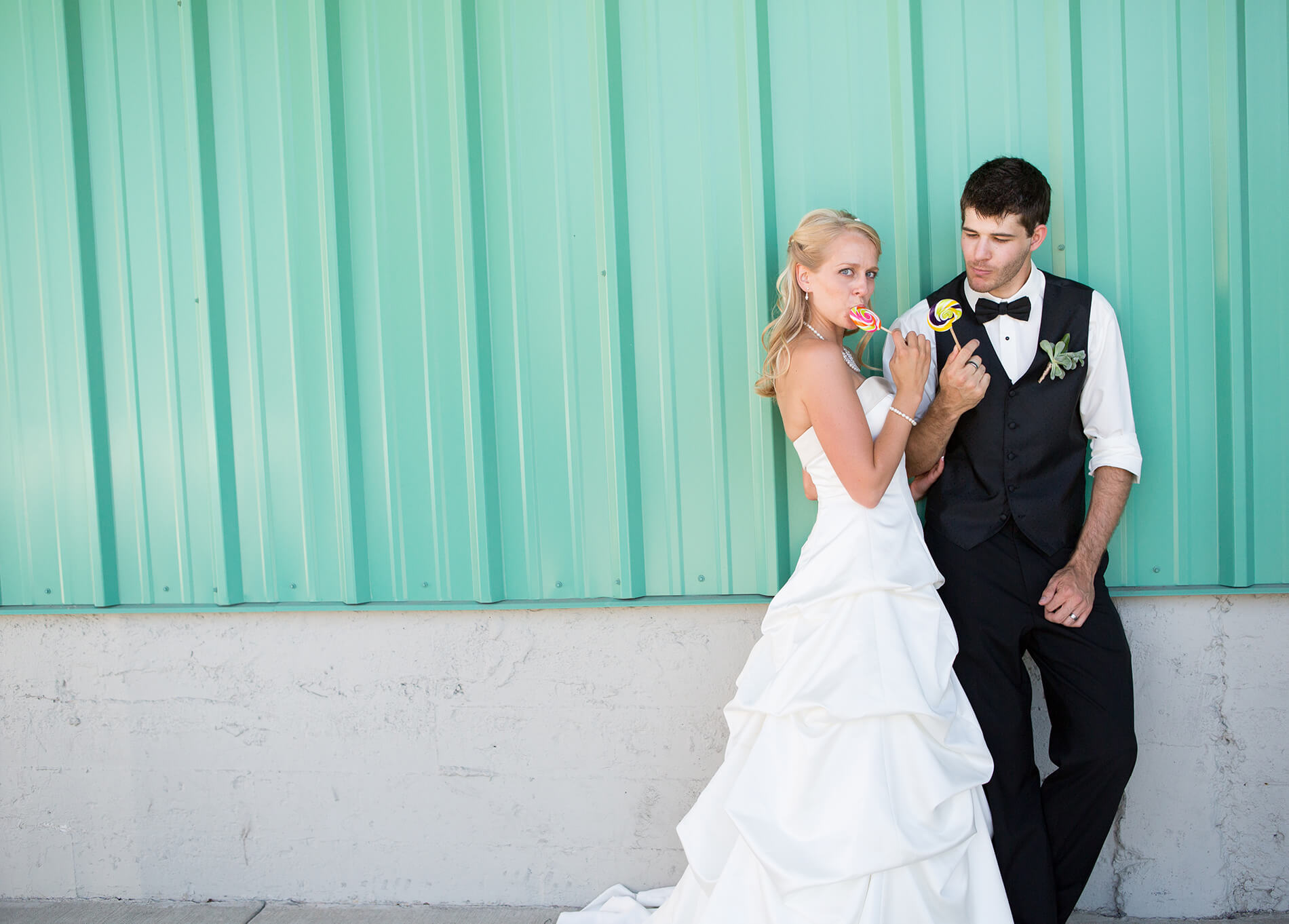 Newly married couple stands in front of urban teal warehouse wedding photography billings mt