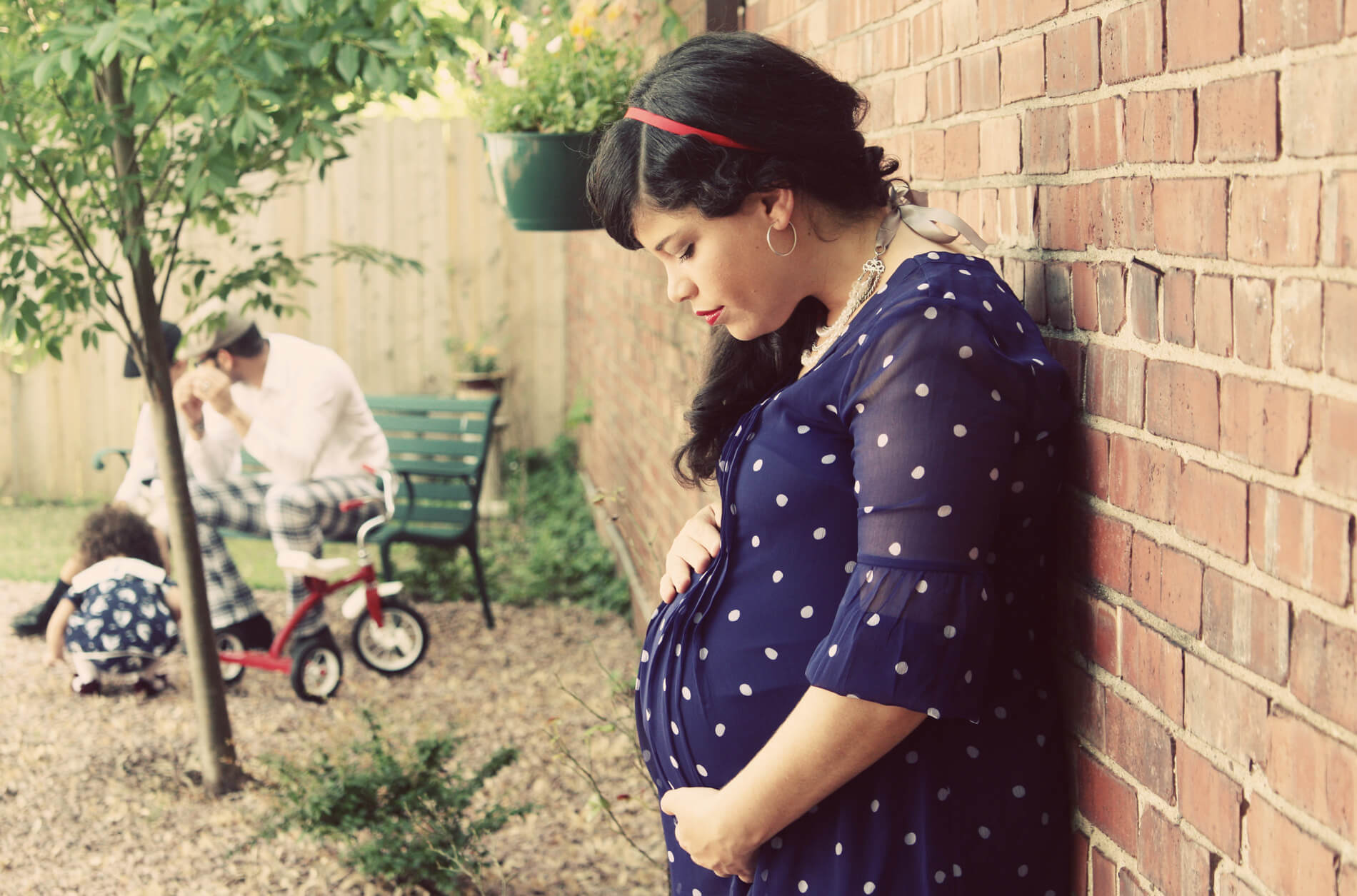 beautiful pregnant woman in 1920's clothing rests up against the wall maternity photography