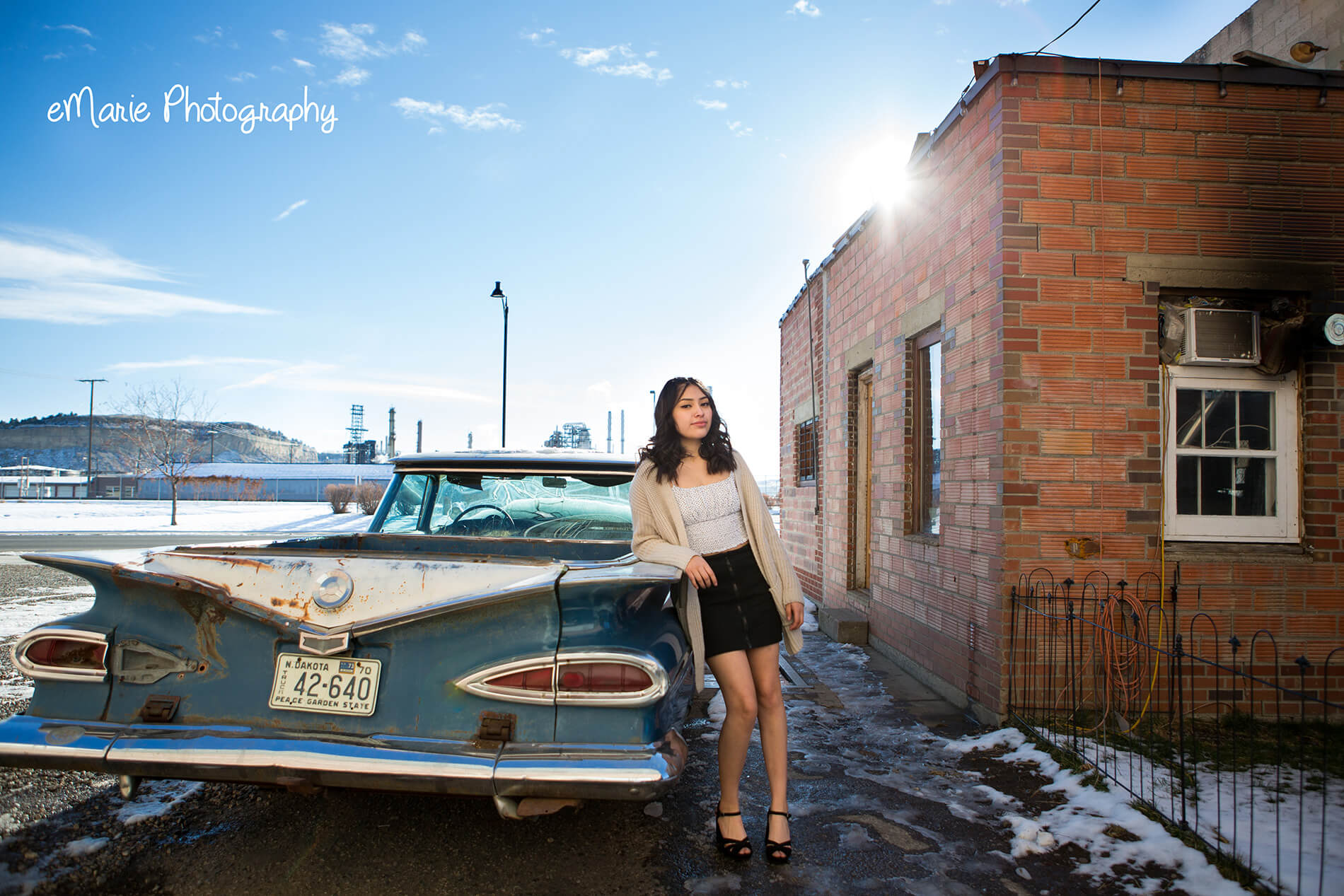High School Senior Girl rests against classic car outside in beautiful montana big sky country