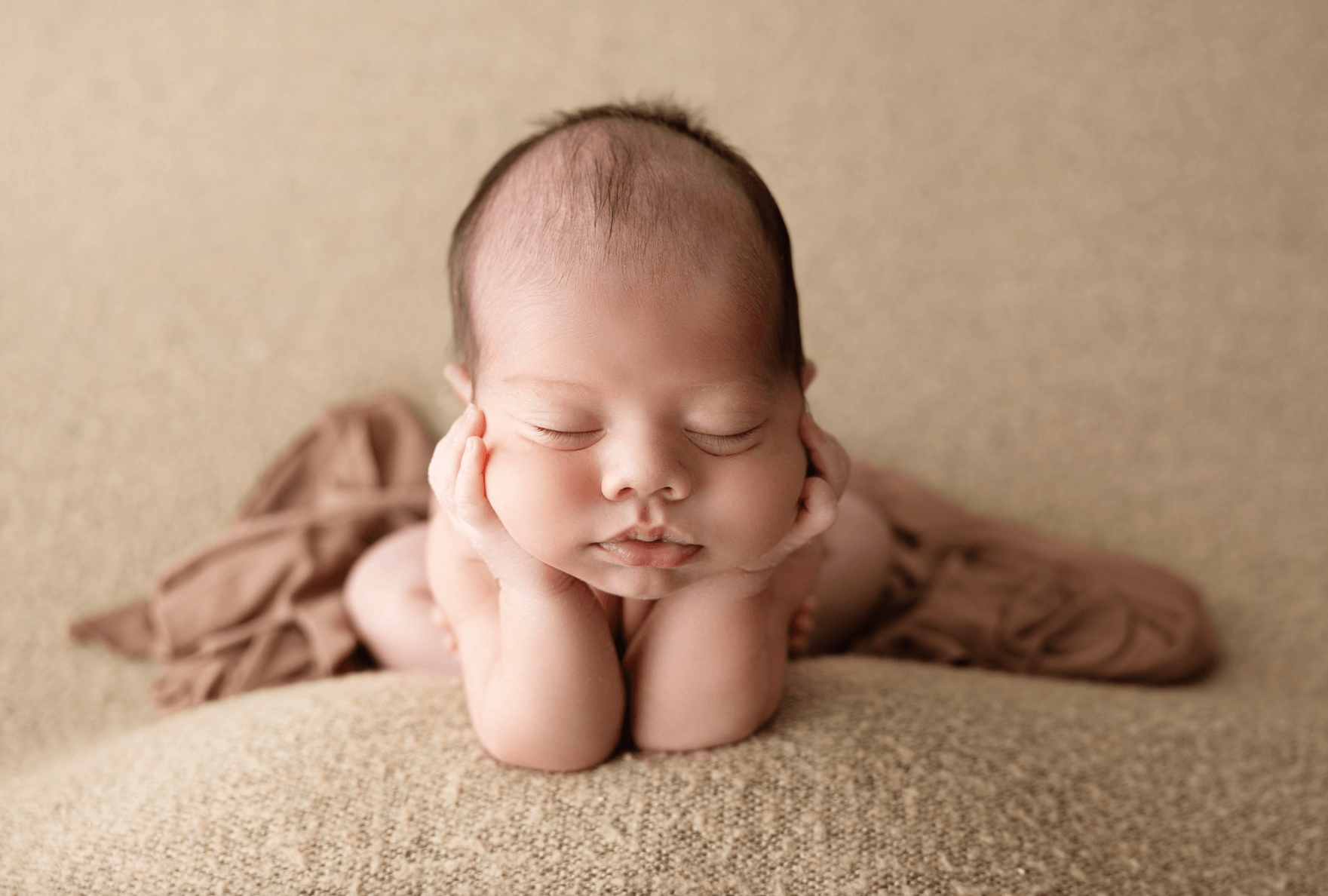 the froggy pose for newborn photography. a baby girl sleeps in a studio wicker basket. a cute older sister lovingly snuggles her sleeping newborn brother. best newborn photographer in Billings MT
